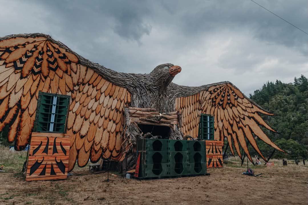 A huge wooden poakai/Haast eagle, its body made of driftwood and wing feathers of layered ply. Between its claws you can see into the DJ booth.